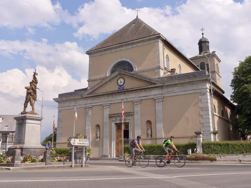 Cyclists in front of Saint-Jean-Baptiste Church in Taninges
