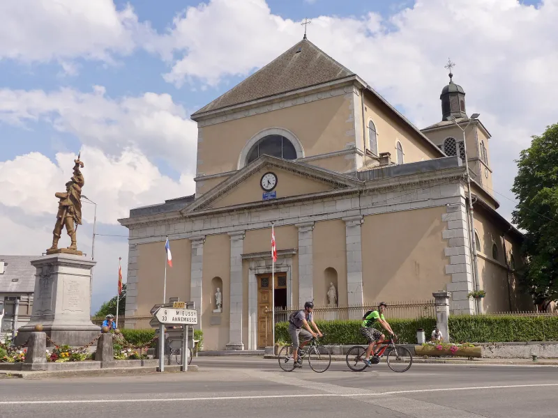 Cyclists in front of Saint-Jean-Baptiste Church in Taninges