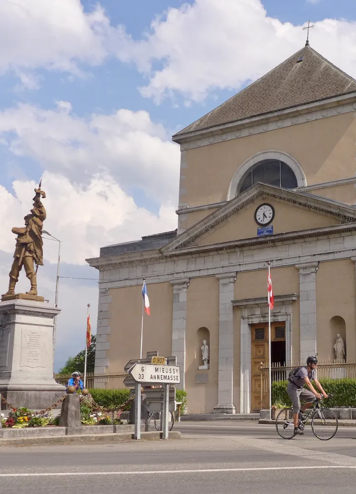 Cyclists in front of Saint-Jean-Baptiste Church in Taninges