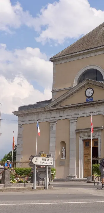 Cyclists in front of Saint-Jean-Baptiste Church in Taninges