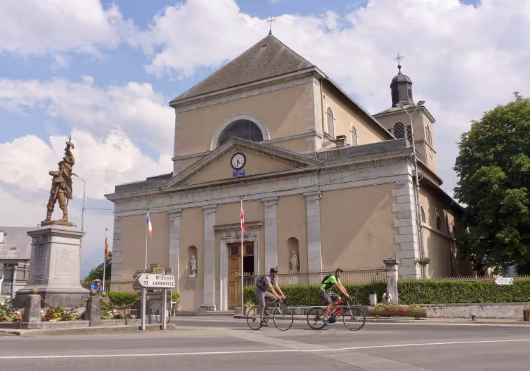 Cyclists in front of Saint-Jean-Baptiste Church in Taninges