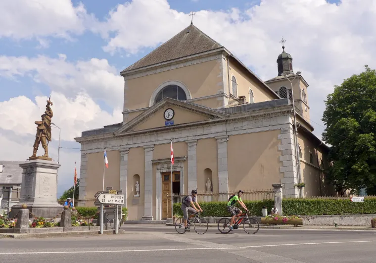 Cyclists in front of Saint-Jean-Baptiste Church in Taninges